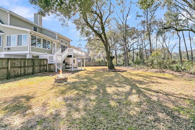 view of yard featuring stairs, an outdoor fire pit, a fenced backyard, and a wooden deck