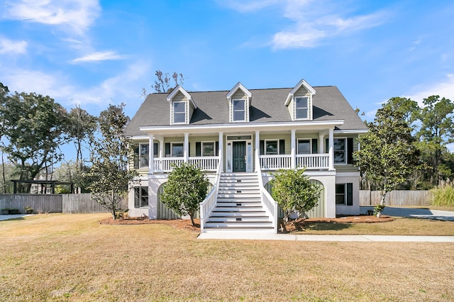 view of front of house with covered porch, stairway, a front yard, and fence