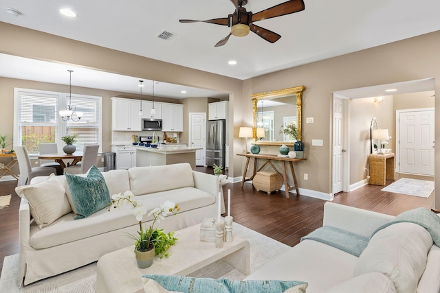 living room featuring hardwood / wood-style floors and ceiling fan with notable chandelier