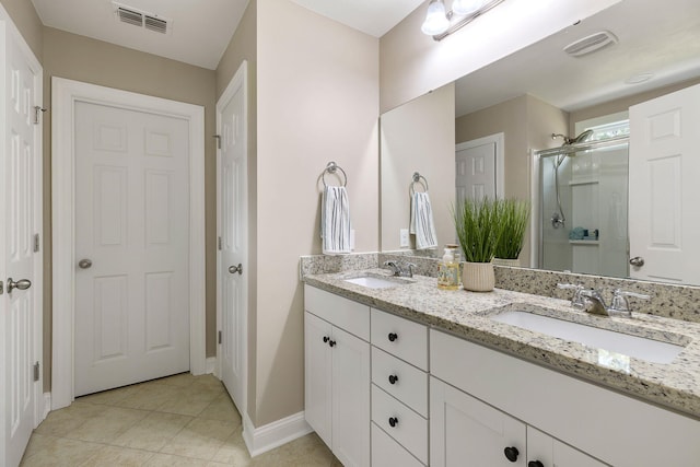 bathroom with an enclosed shower, vanity, and tile patterned floors