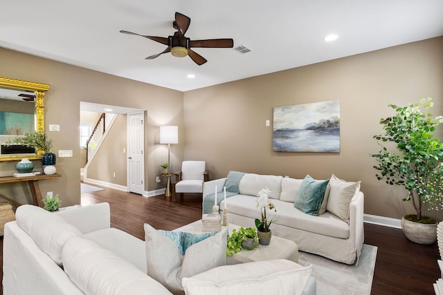 living room with dark wood-type flooring and ceiling fan