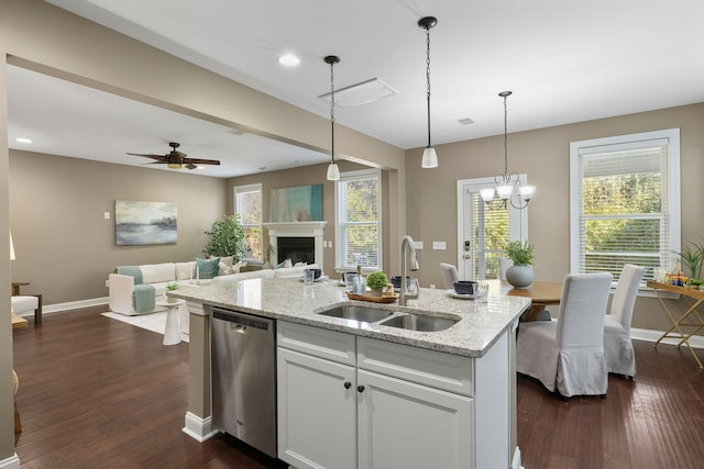 kitchen featuring sink, white cabinetry, hanging light fixtures, light stone countertops, and stainless steel dishwasher