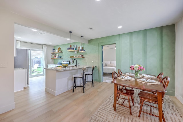 337 Price St, Goose Creek, SC 29445 - dining space with light wood-type flooring, recessed lighting, baseboards, and bar