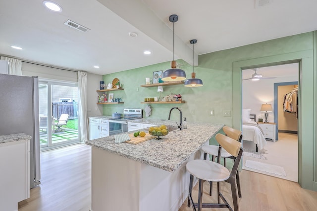 337 Price St, Goose Creek, SC 29445 - kitchen featuring stainless steel appliances, light wood-style flooring, white cabinets, a kitchen bar, and light stone countertops