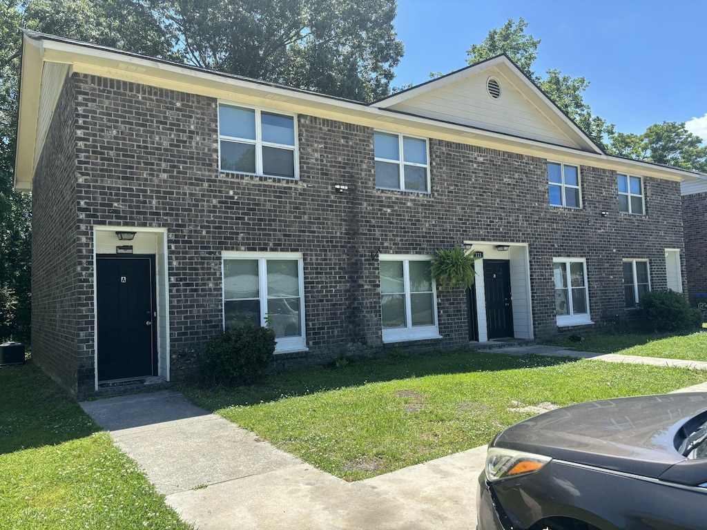 view of front of property featuring brick siding and a front yard