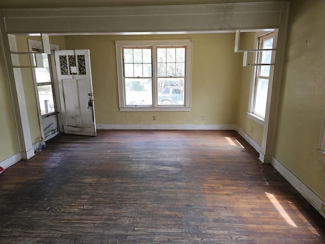 unfurnished dining area with dark wood-style flooring, baseboards, and a healthy amount of sunlight