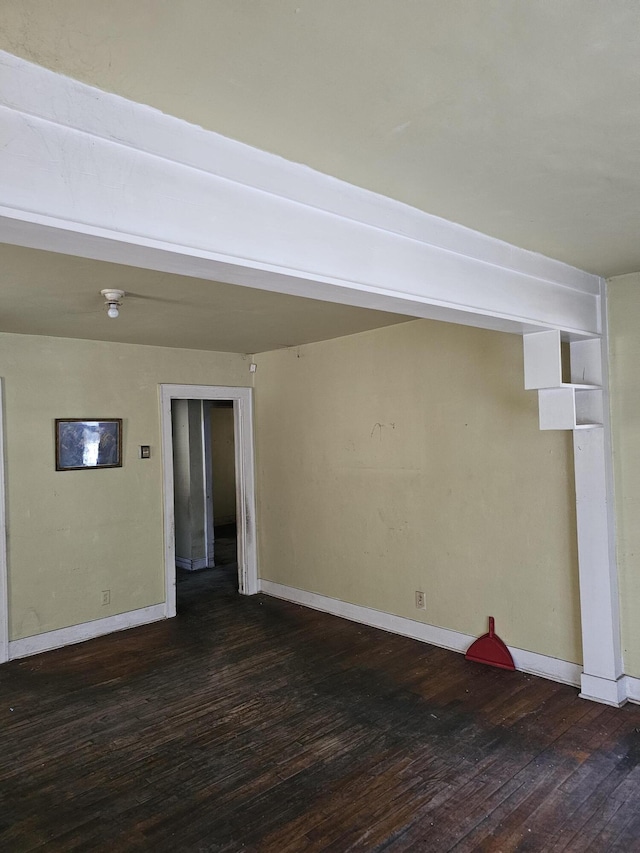 empty room featuring baseboards and hardwood / wood-style floors