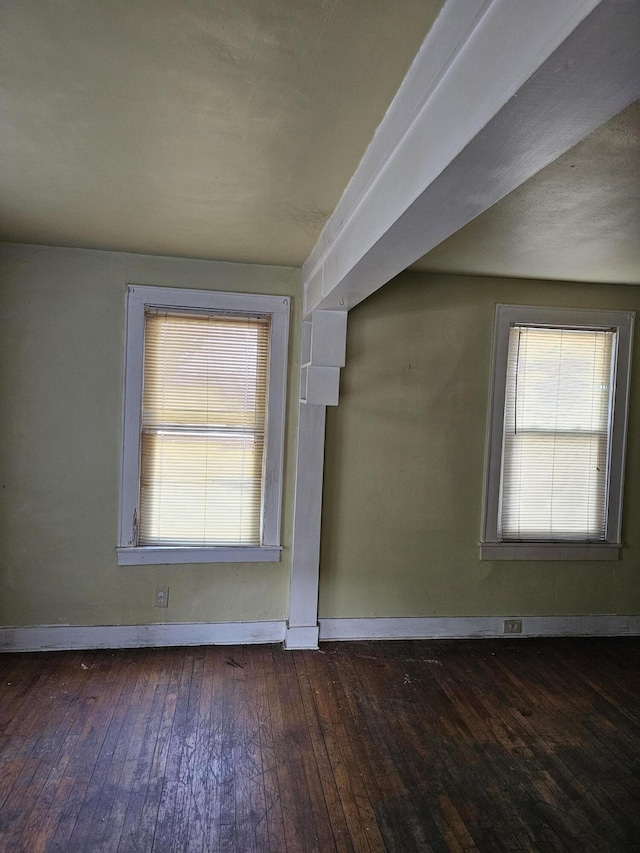 spare room with baseboards and hardwood / wood-style floors