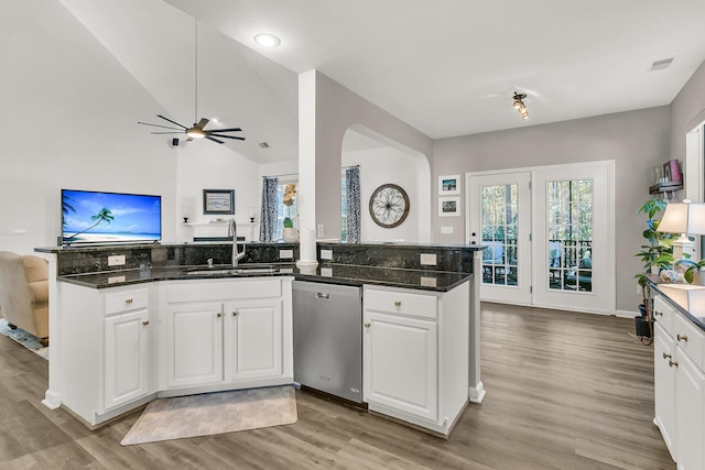 kitchen featuring dark stone countertops, stainless steel dishwasher, and white cabinets