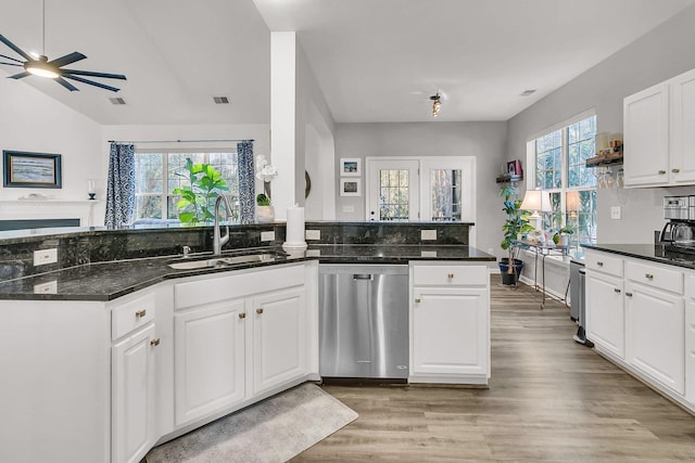 kitchen featuring white cabinetry, sink, stainless steel dishwasher, kitchen peninsula, and plenty of natural light