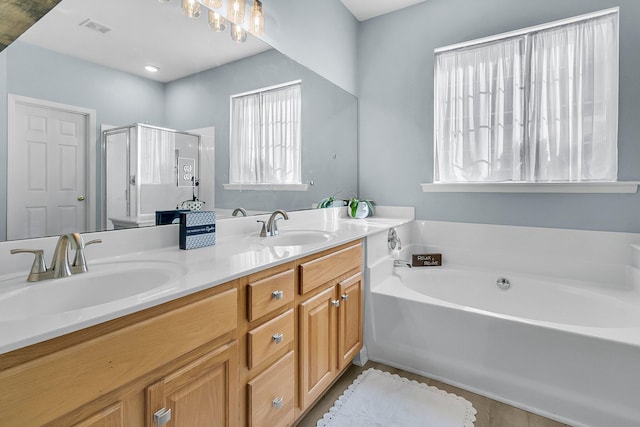 bathroom with vanity and shower with separate bathtub