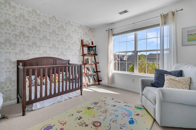 carpeted bedroom featuring a crib