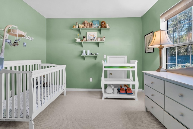 carpeted bedroom featuring a nursery area