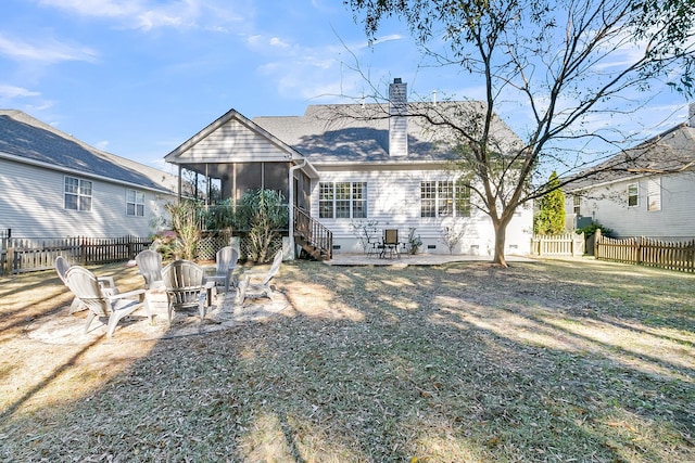 rear view of property with a yard, a sunroom, a patio, and an outdoor fire pit