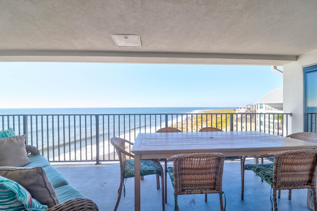 balcony featuring a water view and a beach view