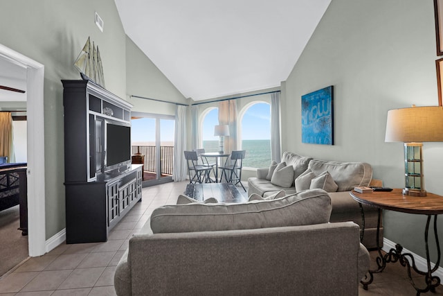 tiled living room featuring high vaulted ceiling