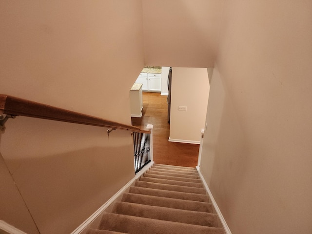 staircase featuring baseboards and wood finished floors