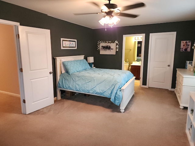 bedroom featuring connected bathroom, light colored carpet, ceiling fan, and baseboards