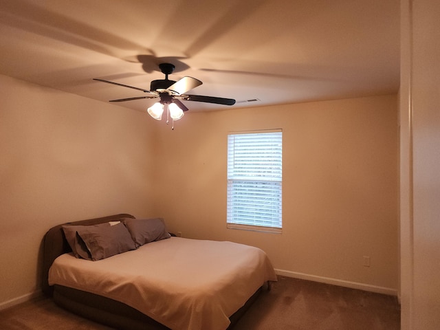 carpeted bedroom featuring a ceiling fan, visible vents, and baseboards