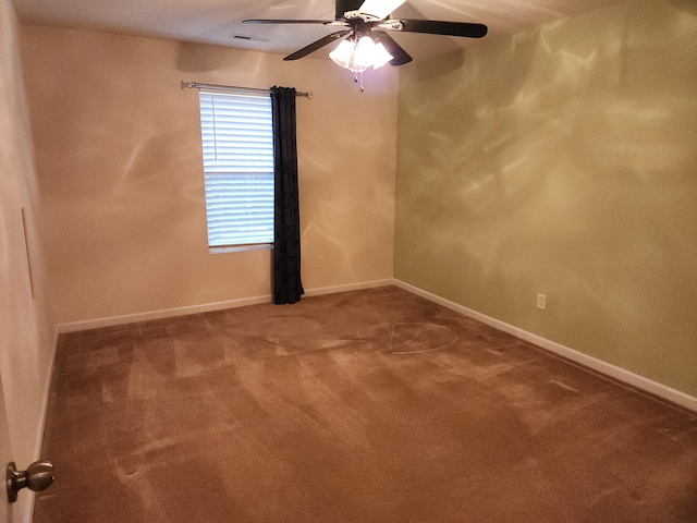 carpeted empty room with ceiling fan, visible vents, and baseboards