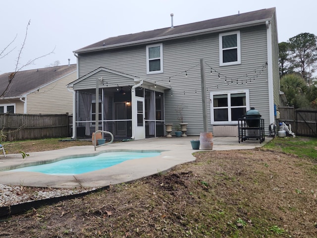 back of property with a patio, a fenced backyard, a sunroom, and a fenced in pool