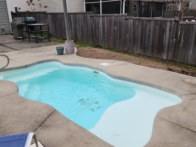 view of swimming pool with a fenced in pool, a fenced backyard, a patio, and grilling area