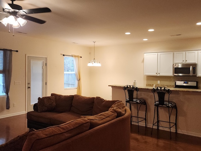 living room featuring a ceiling fan, recessed lighting, dark wood-style flooring, and baseboards