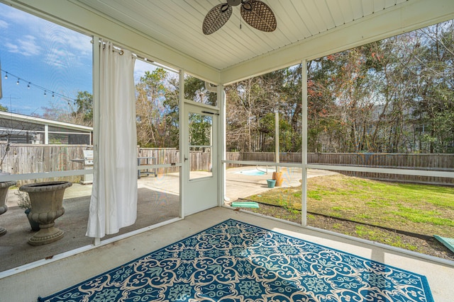 unfurnished sunroom with ceiling fan