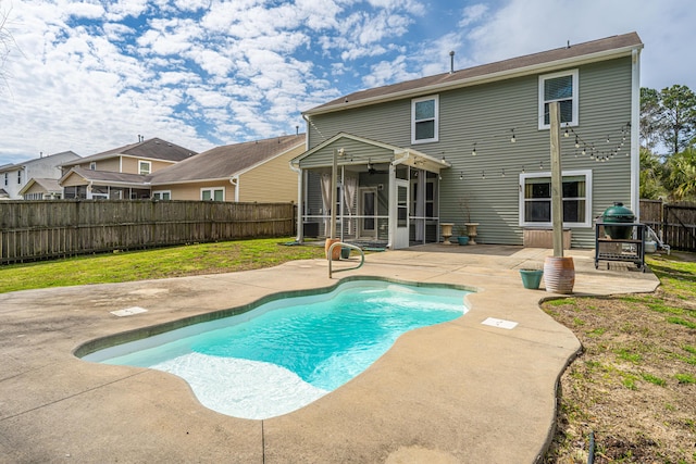 view of pool featuring a fenced in pool, a yard, a patio, a sunroom, and a fenced backyard