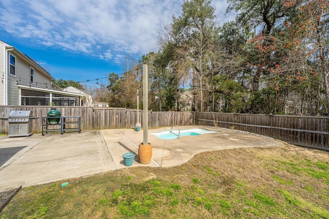 view of swimming pool with a fenced backyard, area for grilling, a yard, a fenced in pool, and a patio area