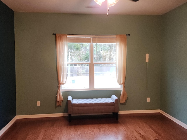 sitting room with wood finished floors, visible vents, and baseboards