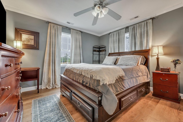 bedroom with light wood-type flooring, ceiling fan, and crown molding