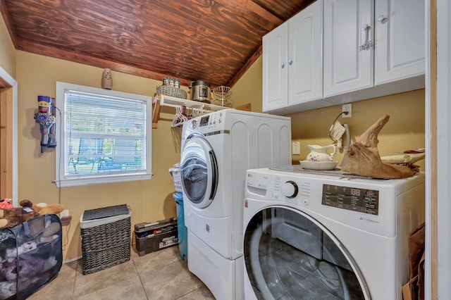 clothes washing area featuring separate washer and dryer, cabinets, light tile patterned floors, and wooden ceiling