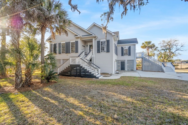 view of front of house with stairway and a front lawn