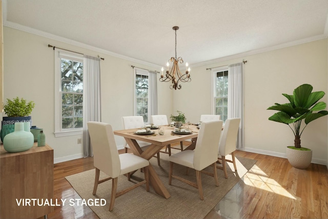 dining room featuring ornamental molding, light wood-type flooring, and baseboards