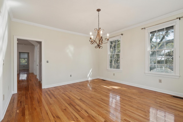 unfurnished dining area with light wood finished floors, visible vents, ornamental molding, a chandelier, and baseboards