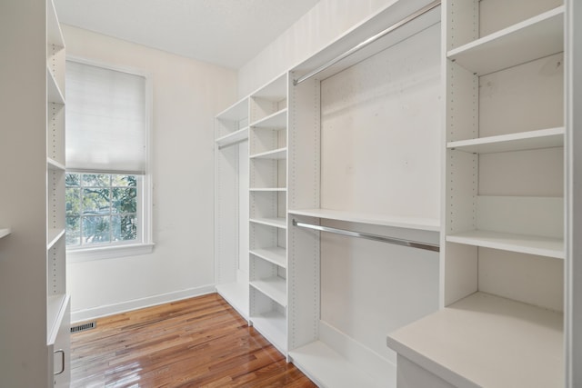 spacious closet featuring visible vents and wood finished floors