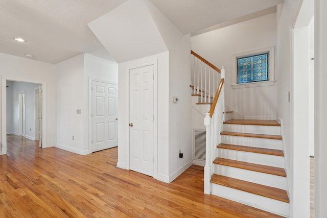 stairs with recessed lighting, visible vents, baseboards, and wood finished floors