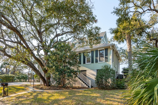 view of front of home featuring stairway and a front yard