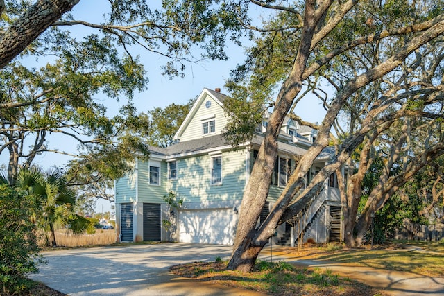 view of front of property featuring driveway, stairway, and an attached garage