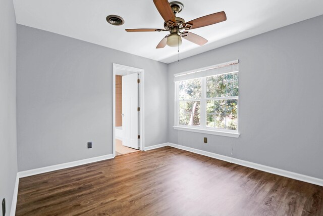 spare room with ceiling fan and dark hardwood / wood-style flooring