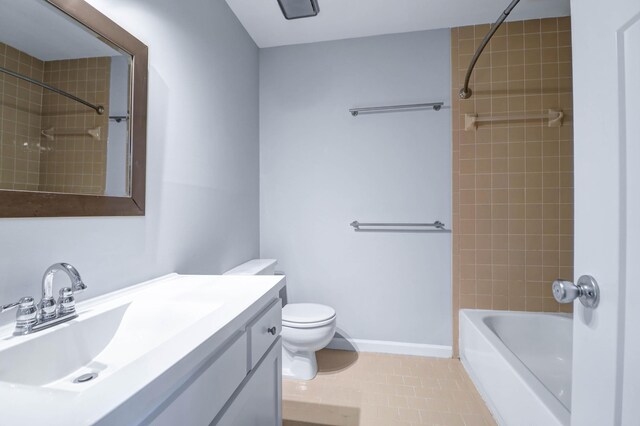 full bathroom with tile patterned flooring, toilet, tiled shower / bath, and vanity