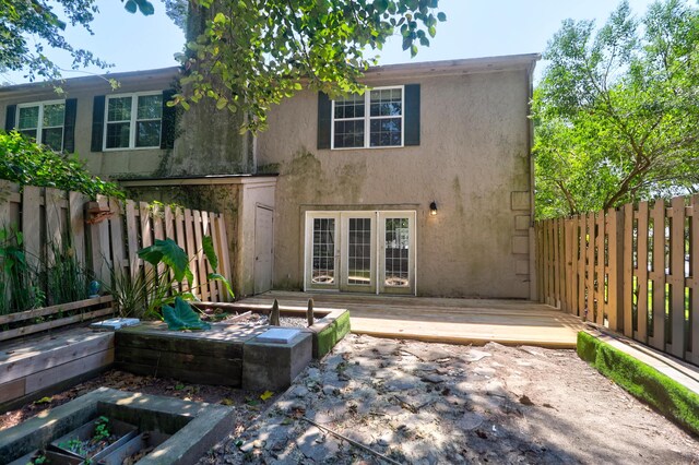 rear view of house featuring a deck and french doors