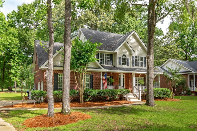 5195 Forest Oaks Dr, Hollywood, SC 29449 - view of front of house with covered porch, brick siding, roof with shingles, and a front yard