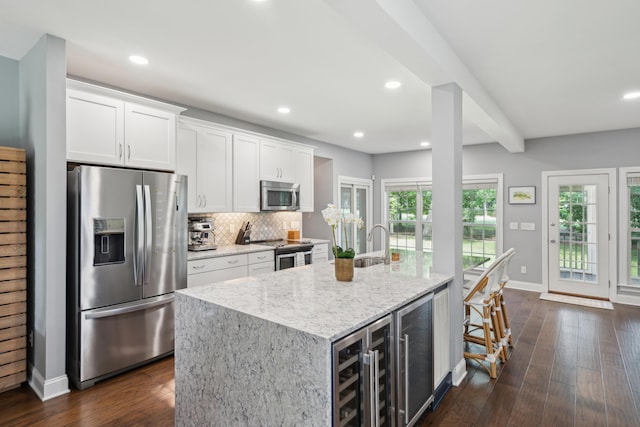 5195 Forest Oaks Dr, Hollywood, SC 29449 - kitchen with appliances with stainless steel finishes, beverage cooler, light stone countertops, white cabinets, and baseboards