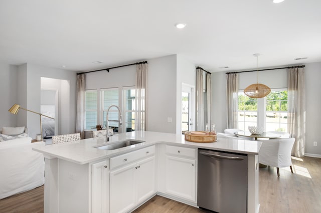 kitchen featuring dishwasher, sink, hanging light fixtures, light hardwood / wood-style floors, and white cabinetry