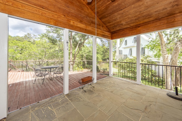 unfurnished sunroom with wood ceiling, lofted ceiling, and a healthy amount of sunlight