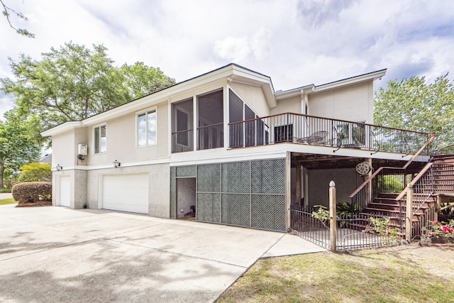 view of front of home featuring a deck, a garage, and a sunroom