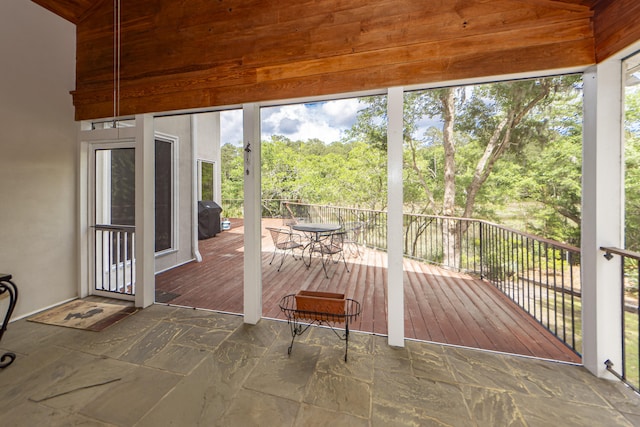 unfurnished sunroom featuring vaulted ceiling