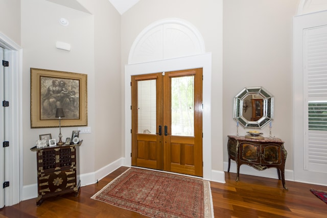 foyer entrance featuring french doors, dark hardwood / wood-style flooring, and vaulted ceiling